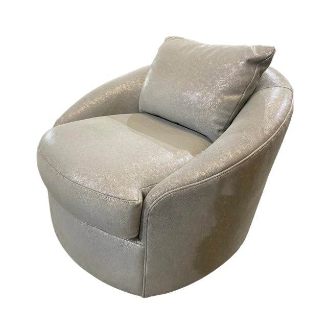 This trendy swivel chair is a gorgeous conversation piece in upholstered silver glittering leather. It features a smooth...