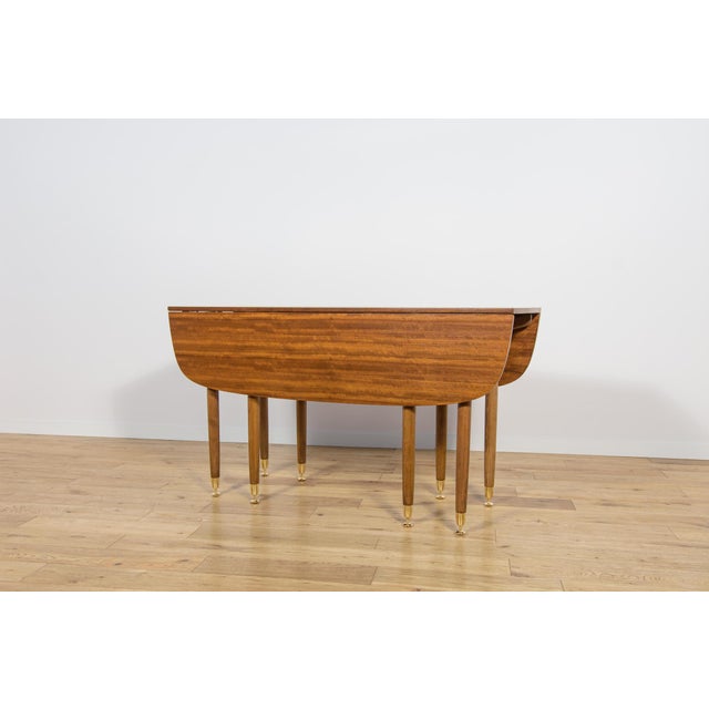 This extendable table was manufactured by the British manufacturer G-Plan in the 1950s. Brass feet add elegance to the...