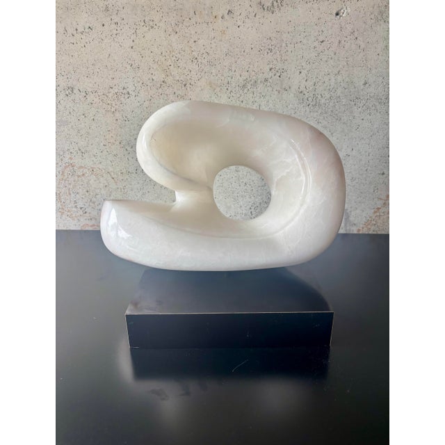 A striking 1970s carved marble abstract sculpture in the style of Henry Moore, featuring a fluid biomorphic form with a...