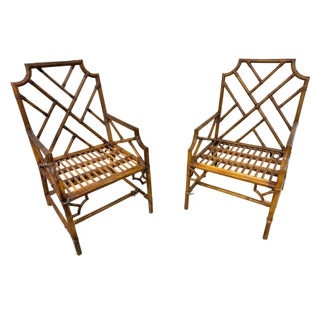 Add a touch of coastal sophistication to your home with this pair of vintage circa 1970s bamboo and rattan armchairs....