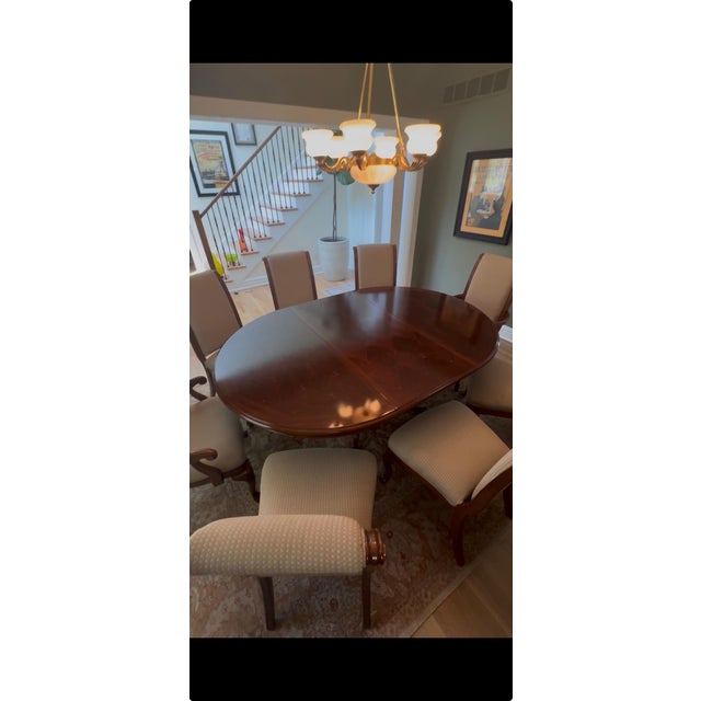 Traditional regency style hardwood dining table and 8 Queen Anne style upholstered high back chairs, includes two arm...