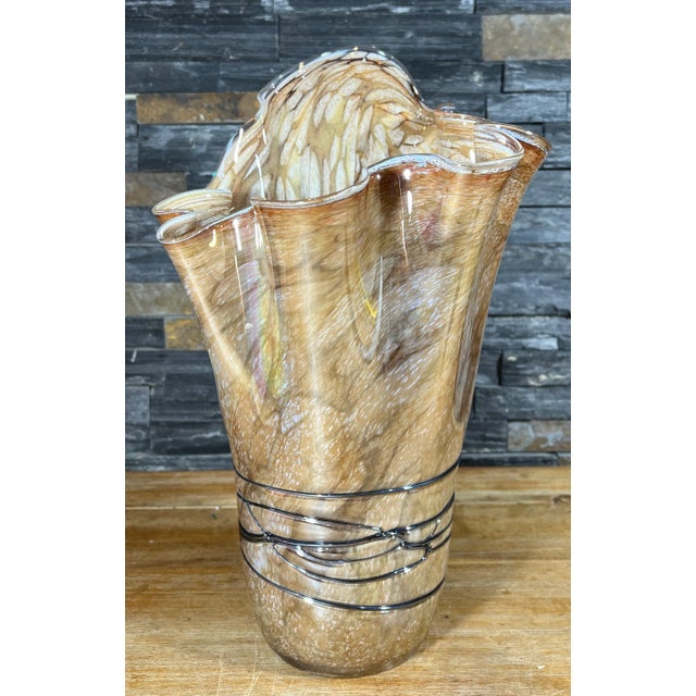 This 15 1/2-inch tall Art Glass vase bears witness to the masterful touch of skilled glass artisans. Crafted from a...