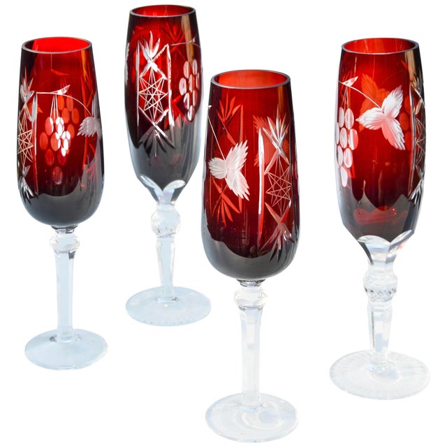 A spectacular set of four midcentury handblown cut-to-clear stemmed glasses, exhibiting an elegantly hand-cut grapes and...