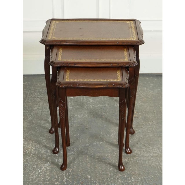 Vintage Nest of Tables with a Lovely Brown Leather Top. A charming and elegant piece of furniture designed in the Queen...