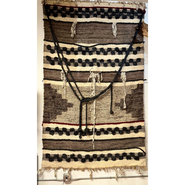 A large vintage wool weaving in earth tones. There is a dark burgundy stripe near the bottom. 1970’s vintage. It measures...
