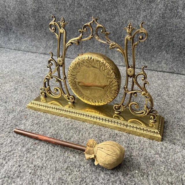 This 19th Century brass gong features an ornate pierced brass stand with scrolling foliate details and a finely hammered...
