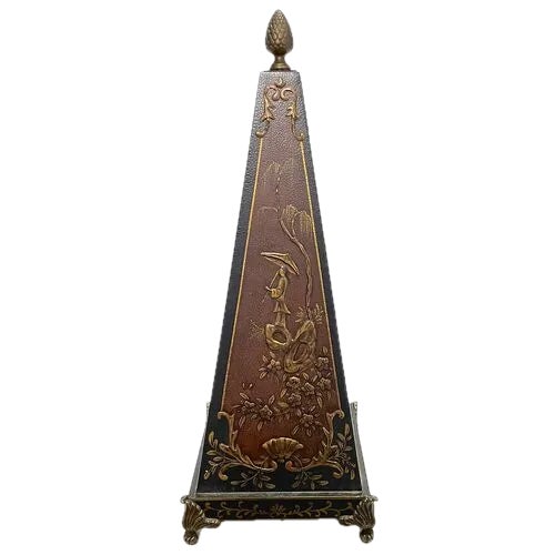 Vintage Chinoiserie style obelisk with brass accents. Bas relief figurative scene on two sides and temple scene on the...