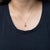 A 1.27-carat padparadscha sapphire oval sits at the centre of this solid 14K yellow gold pendant, framed by thirteen...