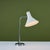 Desk lamp designed by Greta von Nessen c.1960s, USA, for Nessen Studios. The lamp features a white enameled trumpet shade...