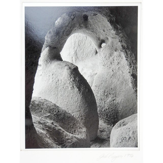 1976 black and white abstract photograph on paper of cave entrance. Signed Jack Puryear in pencil along lower edge of mat....