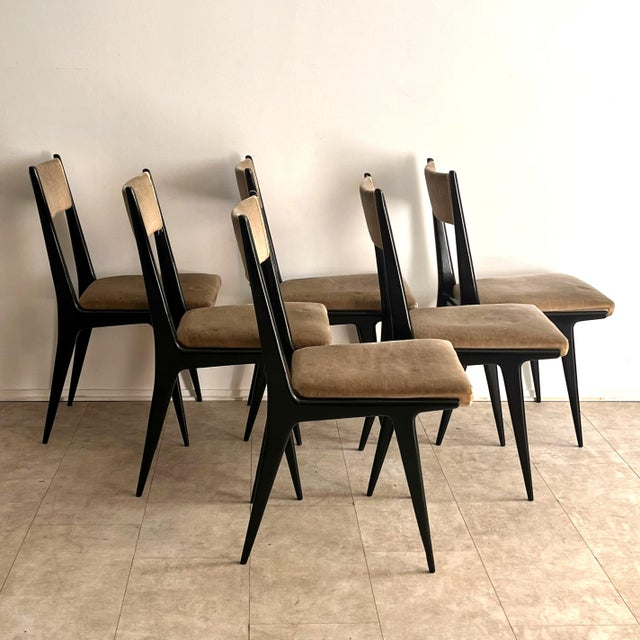 This refined set of six mid-20th-century dining chairs embodies the sculptural elegance of 1950s Italian design, in the...
