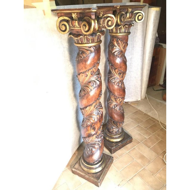 This impressive pair of antique Baroque columns combines sculptural carving with rich gilt details. Each column features a...