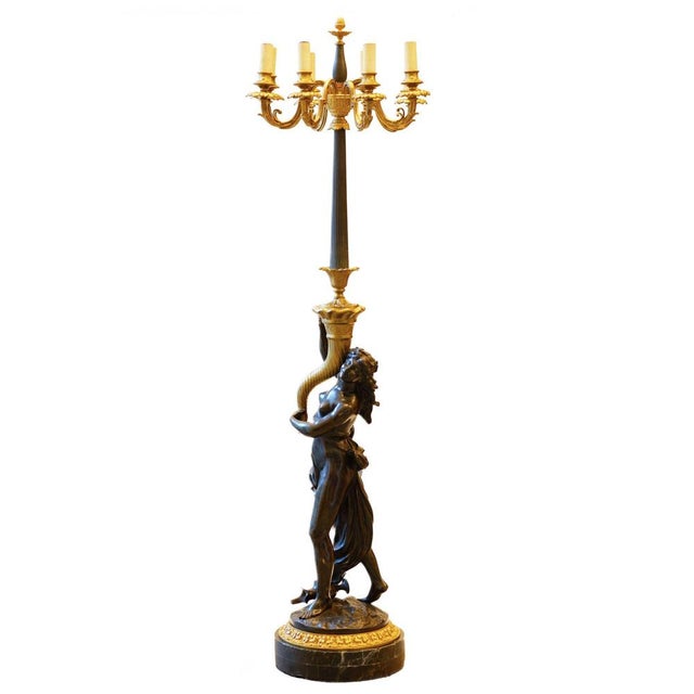 French, sculptural floor lamp made of gilded and patinated bronze for 8 candles, the fluted stem of which is gracefully...