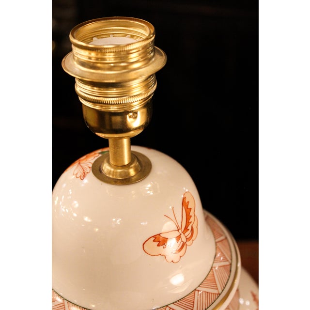 This hand-painted Spanish porcelain lamp is adorned with delicate floral motifs in warm tones, reflecting Spanish...
