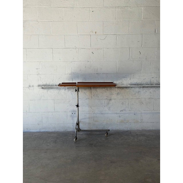 This versatile rolling side table features a dual-tiered top on a height-adjustable chrome tubular steel frame. Its...