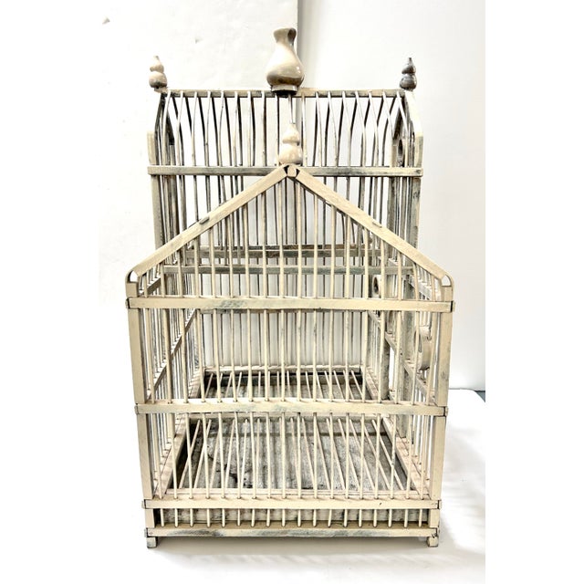 A charming vintage French-style wood and wire birdcage featuring architectural pediment detailing, circular window...