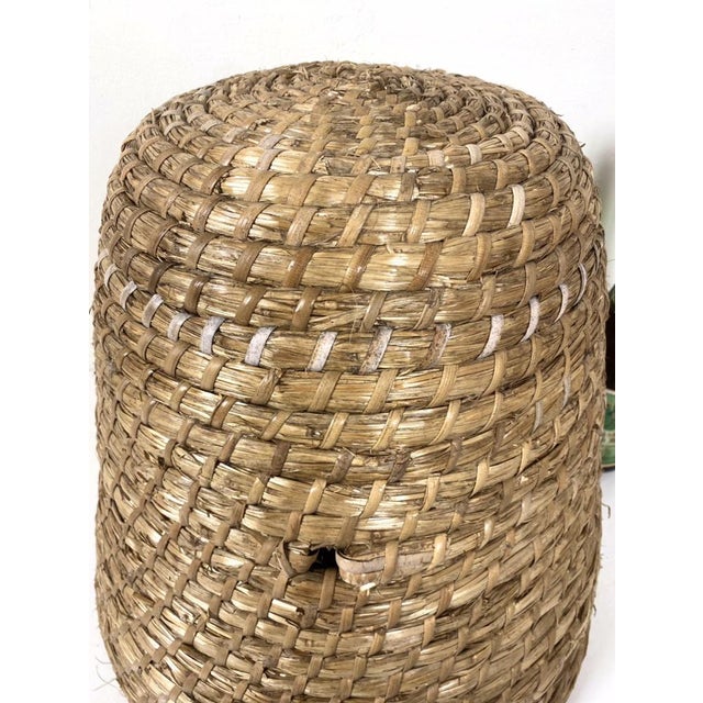 Traditional made round bee hive made of straw or dried grass. Several strands of straw are bundled together to form the...