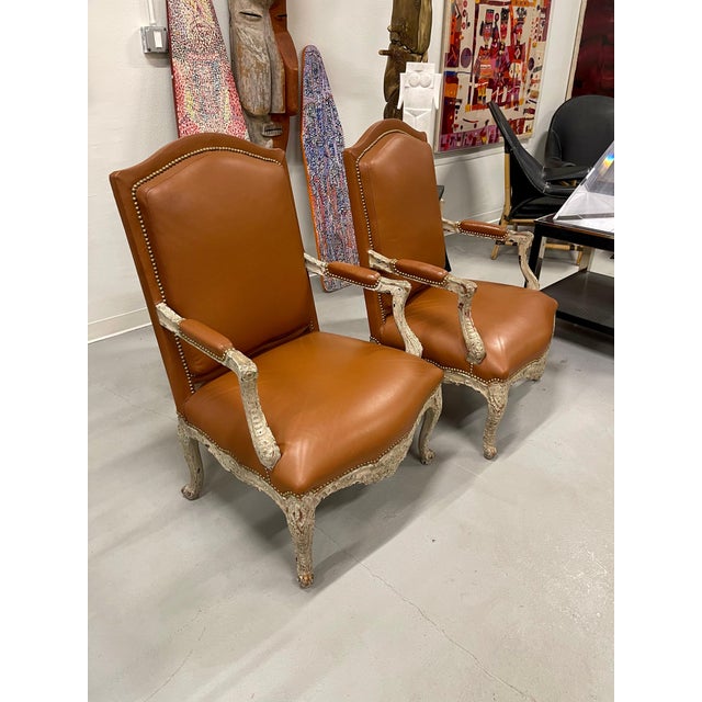 A beautiful pair of 19th century Louis XV Bergeres upholstered in Leather and woven grasscloth. The painted surfaces have...