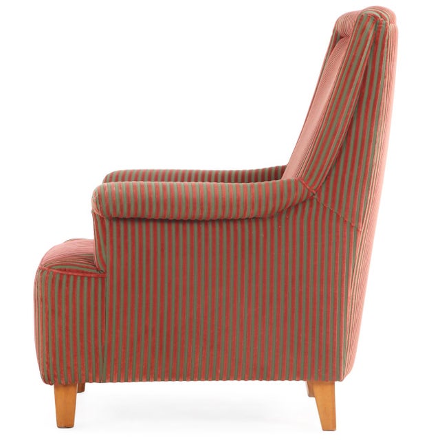 An elegant Italian upholstered lounge chair, circa 1940, retaining its original character and featuring a striking red and...
