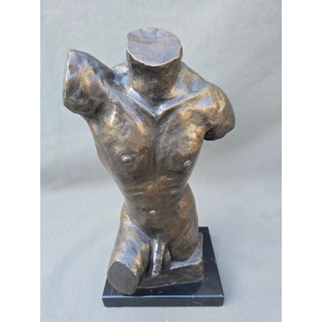 Stunning headless bronze male torso with genitalia on black marble base.