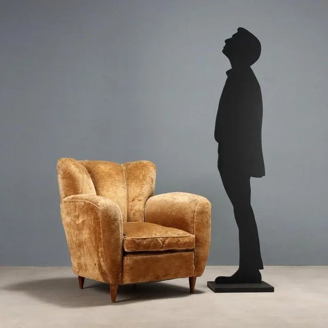 Vintage armchair with sprung padding, a down cushion, and original fabric upholstery in ochre tones; wooden legs. This...