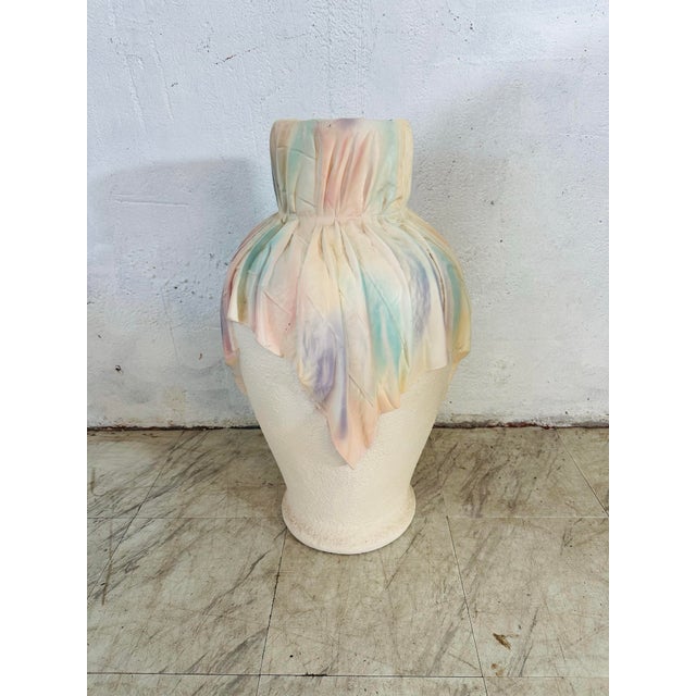 This large vase has a substantial, grounded presence, with a softly rounded body and a narrow, slightly flared opening....