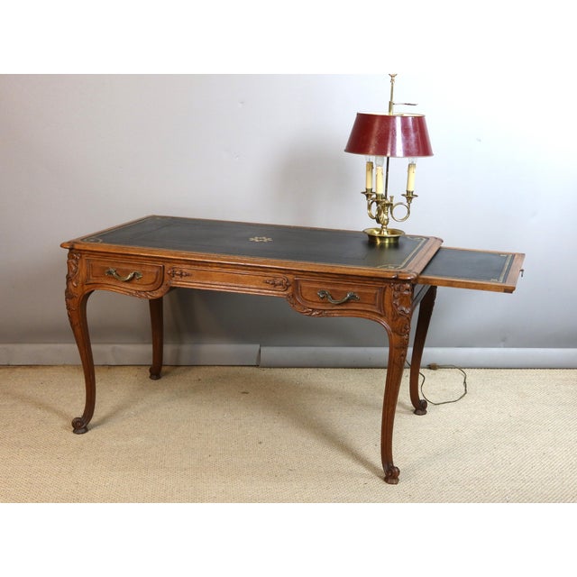 A Louis XV style carved oak desk, late 19th century. This desk features two drawers and a retractable writing surface on...