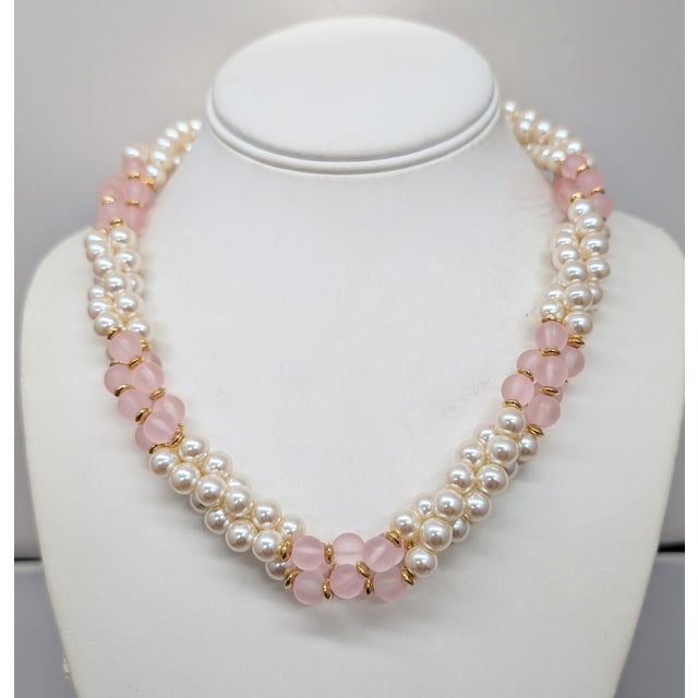 1980s goldtone faux-pearl and frosted pink resin beads torsade necklace with fold over clasp. Marked "Napier" in script on...