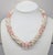 1980s goldtone faux-pearl and frosted pink resin beads torsade necklace with fold over clasp. Marked "Napier" in script on...