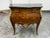 Design Plus Gallery presents a Vintage Louis XV Style Bombe Marquetry Commode. This ornate commode has a bombe case with...