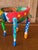 A vibrant hand-painted Alebrije-style folk art giraffe planter featuring bold geometric patterns, playful dots, and...