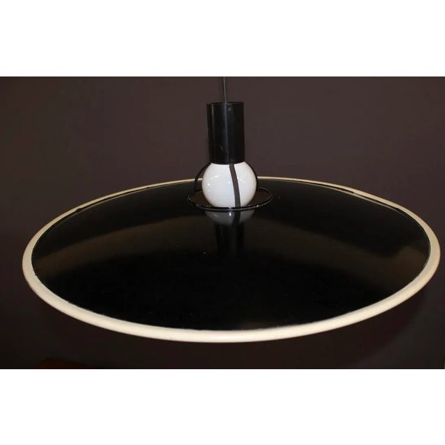 Large hanging lamp in black and white lacquered sheet metal, FLOS, 1980s, in good condition. This piece has an attribution...