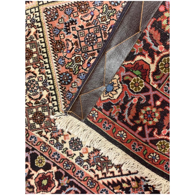 A hand-knotted wool vintage Persian runner with a traditional design that seamlessly complements both modern and...