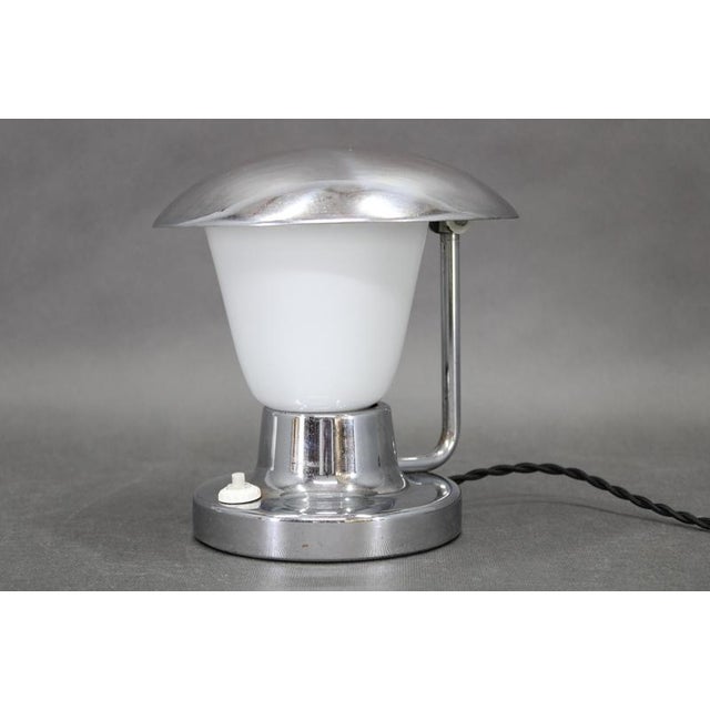 This art deco table lamp was produced by napako in czechoslovakia during the 1930s and exemplifies the refined balance of...