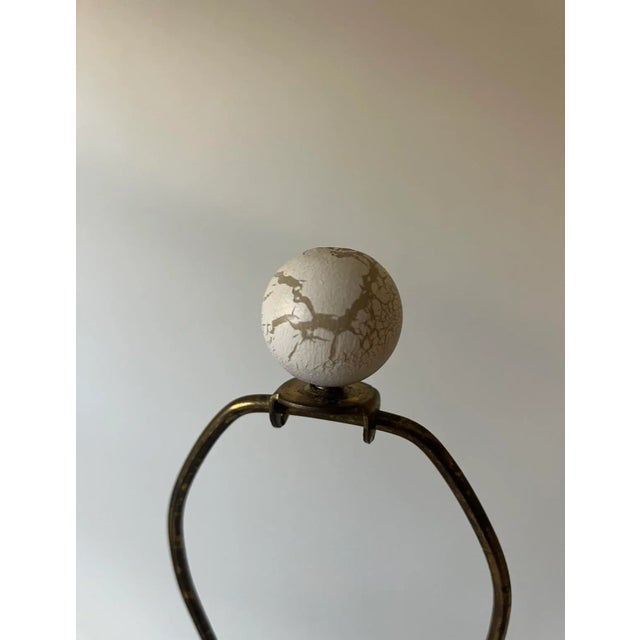 Beautiful pair of beige painted ceramic table lamps with round wooden finials. These lamps feature a curvy silhouette.