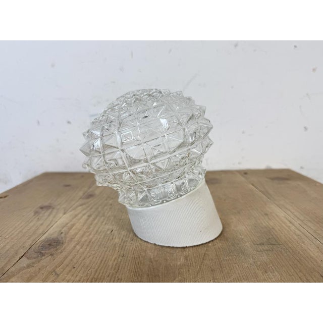Vintage industrial light made in former Czechoslovakia the 1970s. It features a white porcelain wall mounting and a glass...