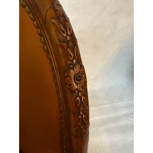 J Nelson leather swivel chair with nailhead trim and beautiful carved wood detailing on frame. Overstuffed leather seat....