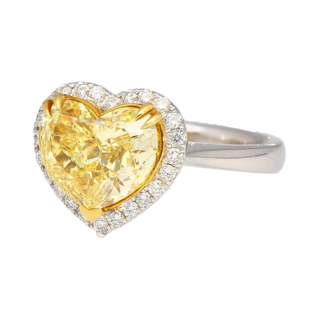 GIA certified 3.32 carat Fancy Intense Yellow natural diamond engagement ring with a round cut white diamond halo. Set in...