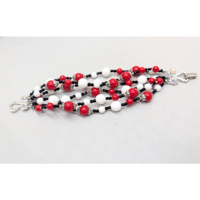 1960s rhodium plated 6-strand bracelet with spherical red and white beads of two sizes with small faceted black beaded...