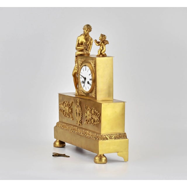 Gilded mantel clock "Venus and Cupid". They represent an Empire pedestal with the figures of Venus and Cupid mounted on...