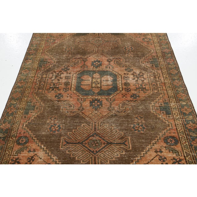 Vintage Persian hand-knotted wool rug with a tan field. This piece has peach and blue accents in an all-over geometric...