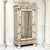 A 19th century Renaissance Revival painted mirrored armoire, finished in a soft ivory patina with gilt and pale silver...