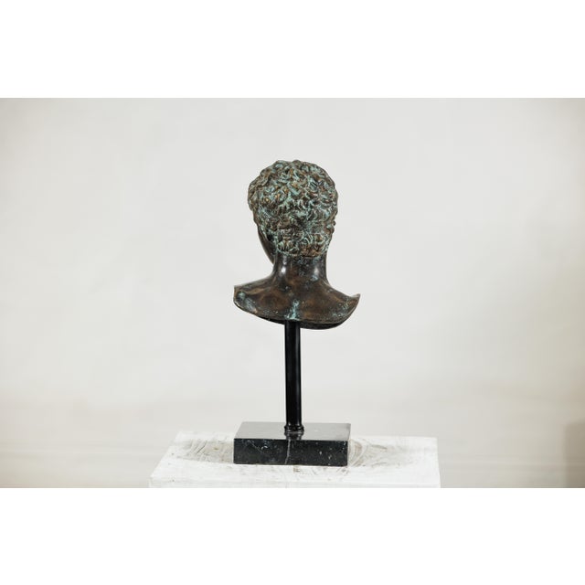 "About the Item This bronze bust of a young man evokes the timeless elegance of classical sculpture. Modeled with softly...
