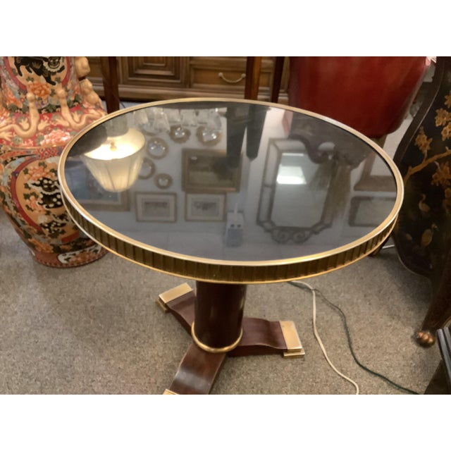 Lovely single pedestal marble top table. Brass surround and brass accents.