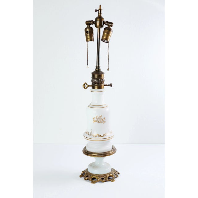 Exceptional Pair of White Milk Glass Oil Table Lamps, Mounted on Gilded Bronze and Electrified. Each lamp features hand...