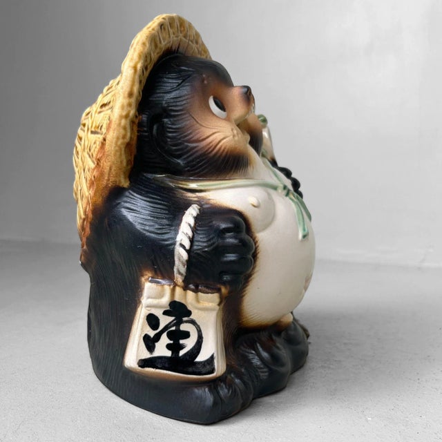 Cheerful Tanuki figure, crafted in the 1980s and originating from Shigaraki — a region renowned for its traditional...