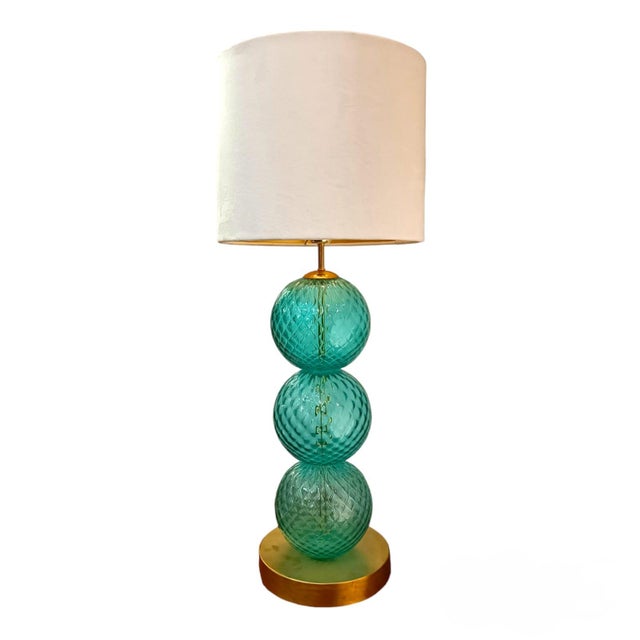 A pair of tall table lamps, made up of three Murano glass balls. The finish of the balls is unique, as they are worked...