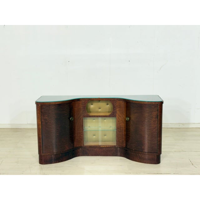 For sale is a stylish vintage bar cabinet from the 1960s. This piece of furniture impresses with its elegant, curved front...