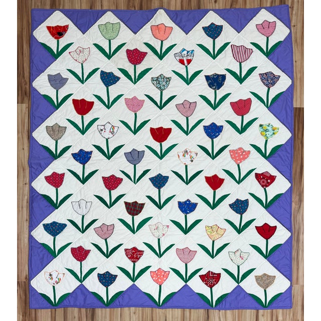 Pair of stunning pieced tulip motif quilts with purple border. Roughly twin size though measures slightly smaller than a...