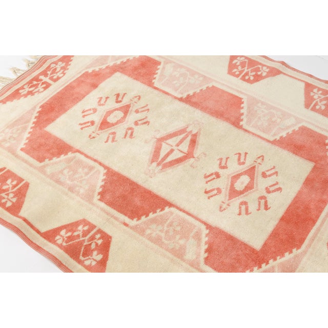 This is a vintage Turkish Oushak rug from the Mid 20th Century. The piece was hand-knotted.